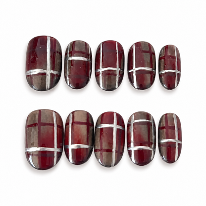 St. Agnes burgundy plaid cateye press-on nail set on a clean white background